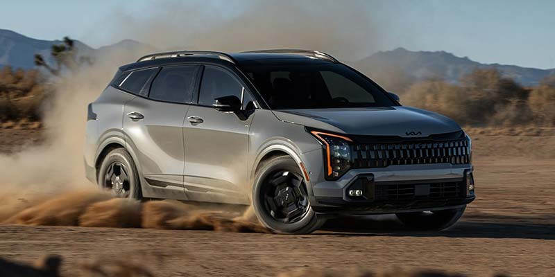 grey 2026 Kia Sportage drifting through sand in an open area